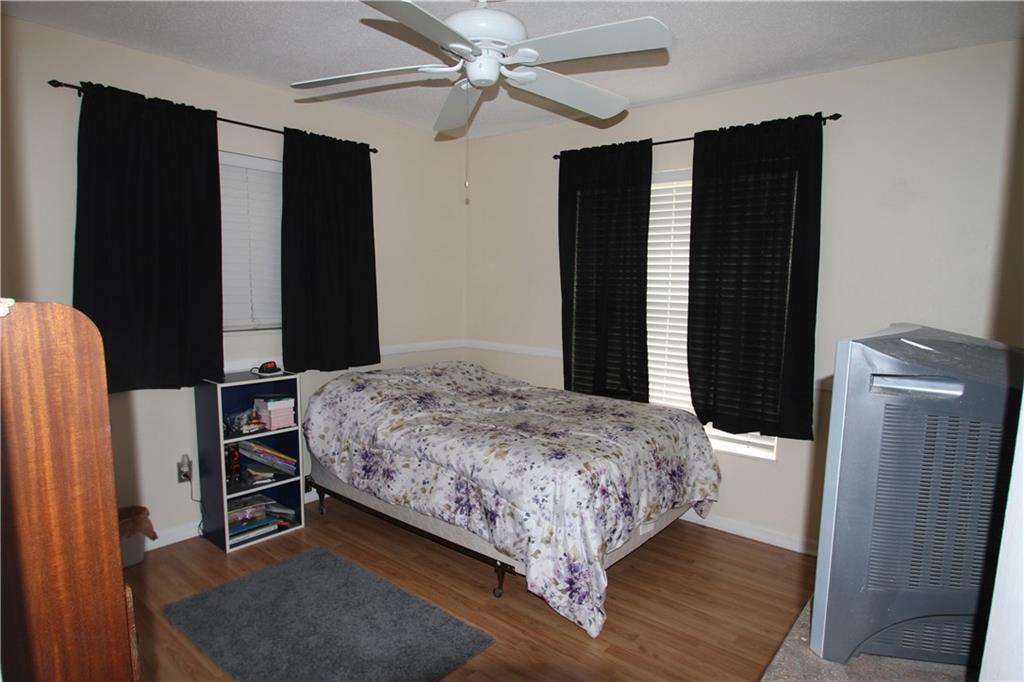 1153 Northwest Spruce Ridge Drive Stuart, FL 34994 - Photo 13 of 22 a bedroom with a bed closet and wooden floor
