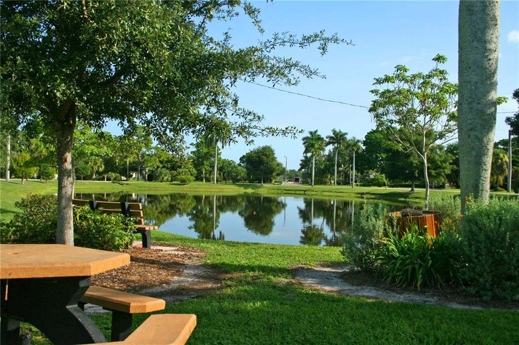 1153 Northwest Spruce Ridge Drive Stuart, FL 34994 - Photo 19 of 22 a view of a lake with a yard and outdoor seating