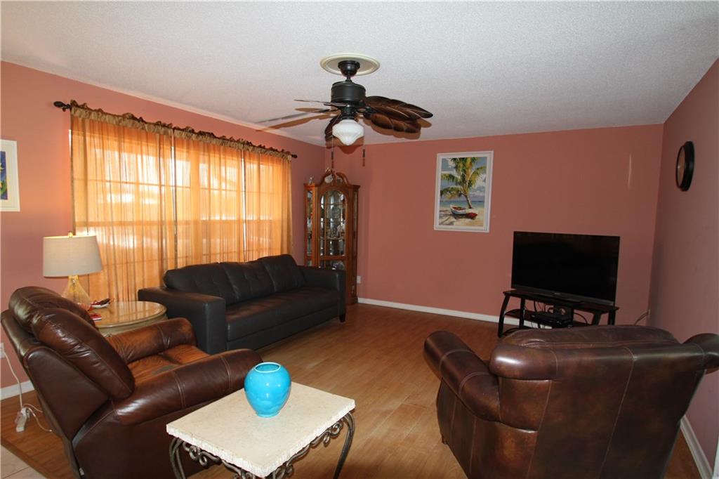 1153 Northwest Spruce Ridge Drive Stuart, FL 34994 - Photo 4 of 22 a living room with furniture a window and a flat screen tv