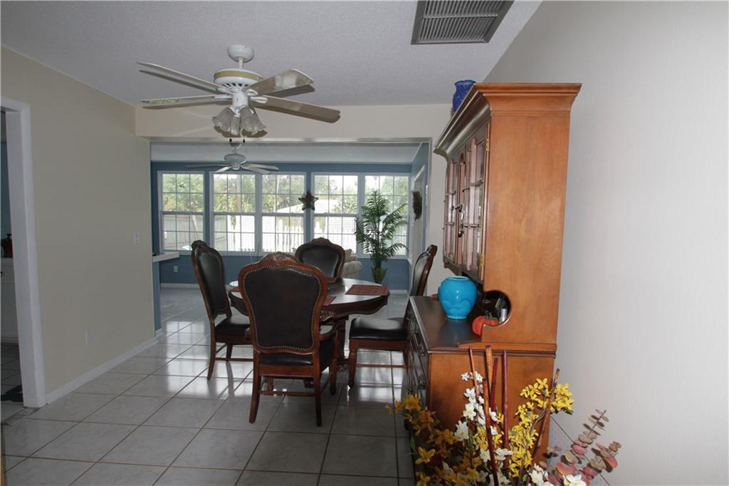 1153 Northwest Spruce Ridge Drive Stuart, FL 34994 - Photo 9 of 22 a view of a dining room with furniture and chandelier