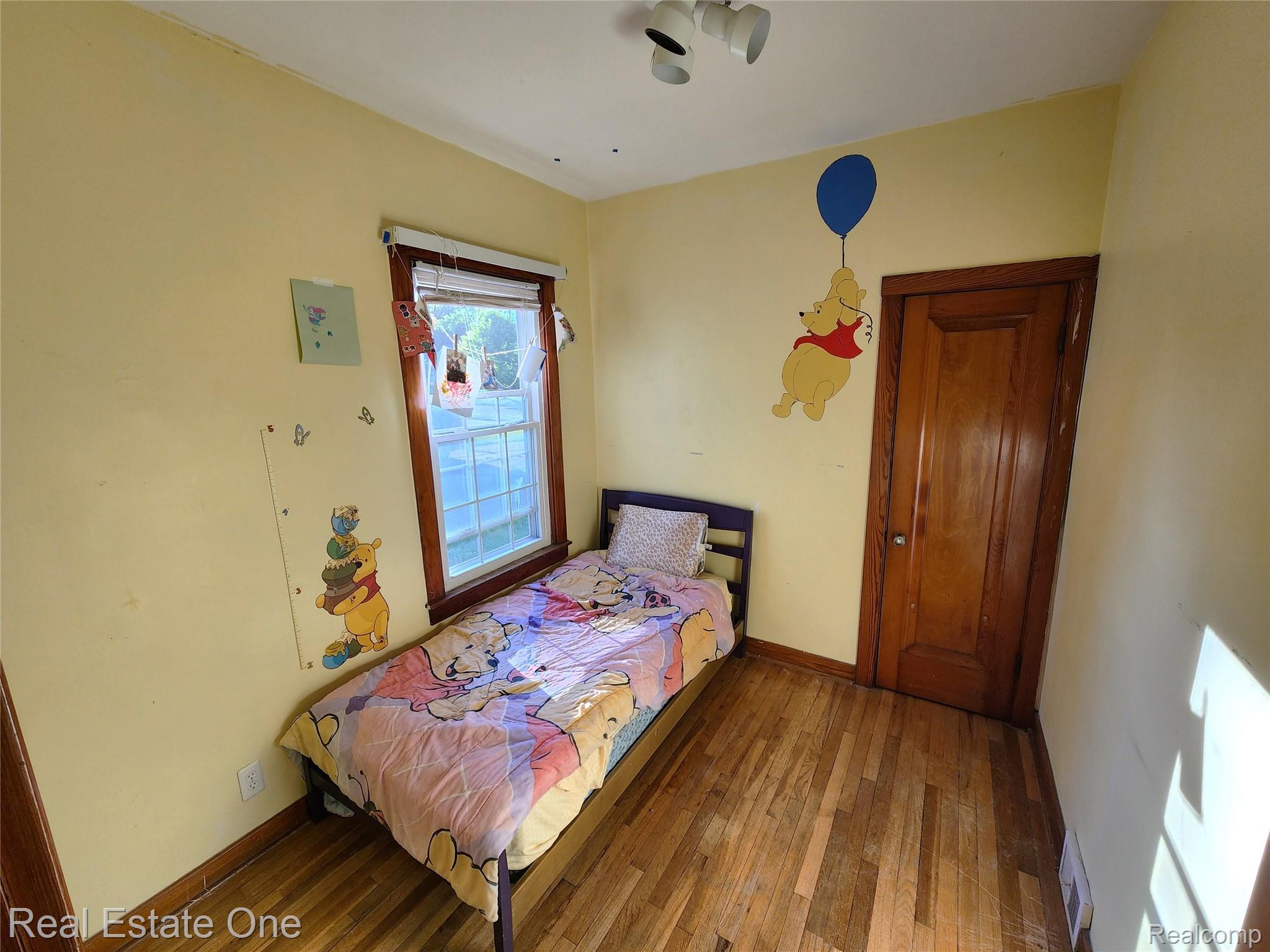 2153 Wiltshire Road Berkley, MI 48072 - Photo 14 of 18 Room featuring hardwood flooring, a single window with blinds, and a paneled wooden door