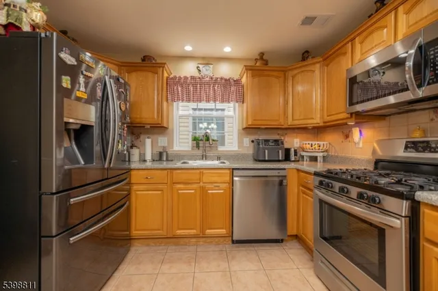 a kitchen with stainless steel appliances granite countertop a stove top oven and refrigerator