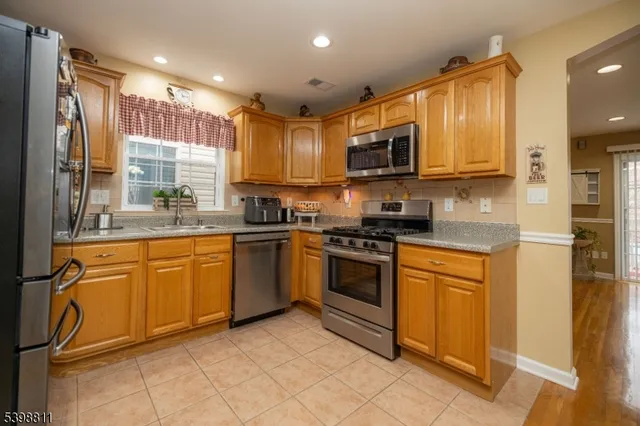 a kitchen with stainless steel appliances granite countertop a stove a sink and a refrigerator