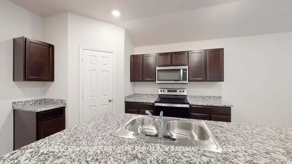 a kitchen with granite countertop a sink and a microwave