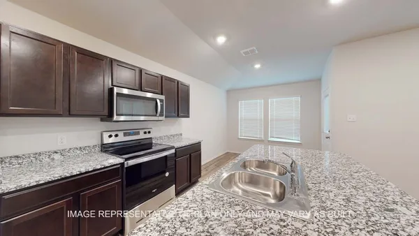 a kitchen with stainless steel appliances granite countertop a sink stove and microwave