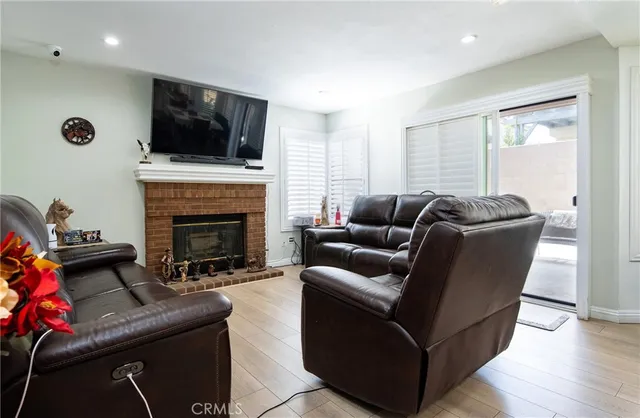 a living room with furniture a flat screen tv and a fireplace