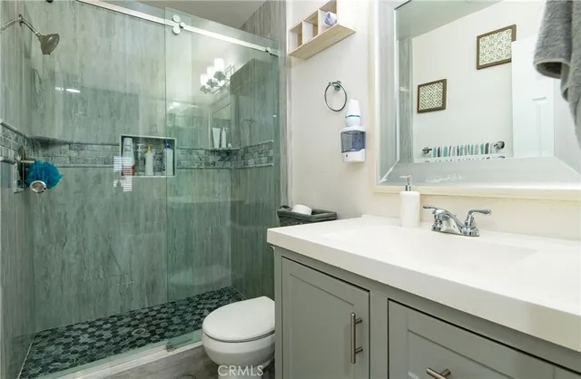 a bathroom with a sink a toilet and shower