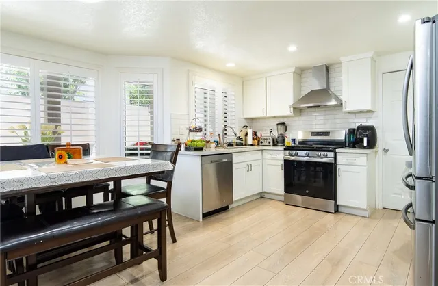 a kitchen with stainless steel appliances granite countertop a stove a sink dishwasher and a refrigerator