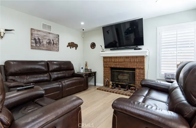 a living room with furniture a flat screen tv and a fireplace