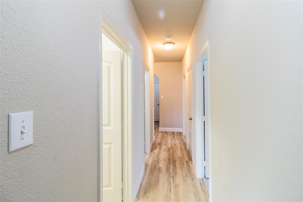 516 Hunt Farms Road Fate, TX 75189 - Photo 17 of 40 Hallway featuring wood-finish flooring, overhead lighting, and crisp white walls