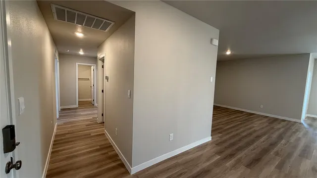 a view of a hallway with wooden floor