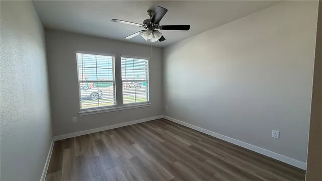 an empty room with a window and a fan