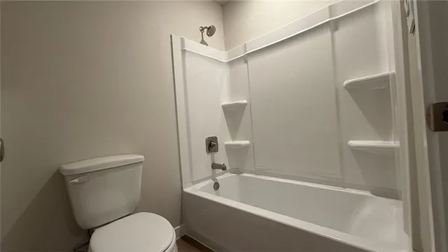 a white toilet sitting next to a bath tub