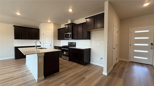 a kitchen with stainless steel appliances kitchen island granite countertop a stove a sink and a refrigerator