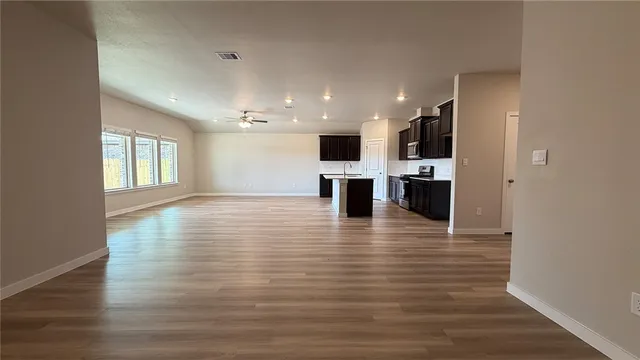 a view of kitchen with stainless steel appliances granite countertop white cabinets and wooden floor