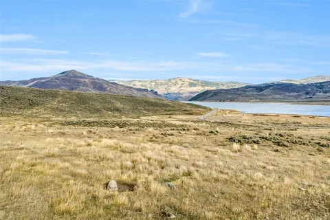 a view of a dry field with a mountain in the background
