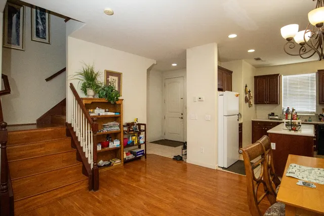 a view of an empty room with kitchen and furniture