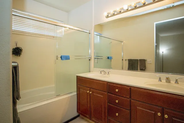 a bathroom with a tub sink and mirror