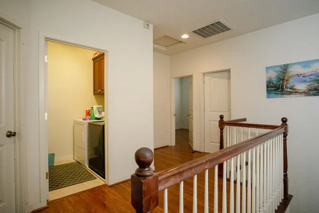 a view of hallway with wooden floor and stairs