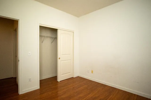 an empty room with wooden floor and closet