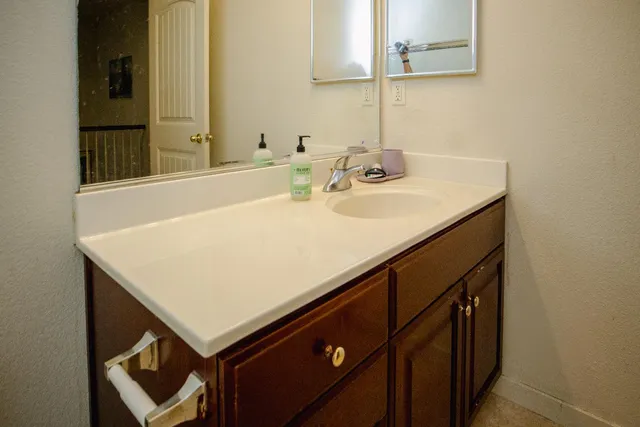 a bathroom with a sink vanity and a mirror
