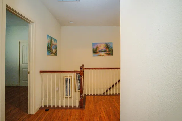 a view of a hallway with wooden floor