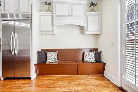 a view of kitchen with stainless steel appliances wooden floor and window