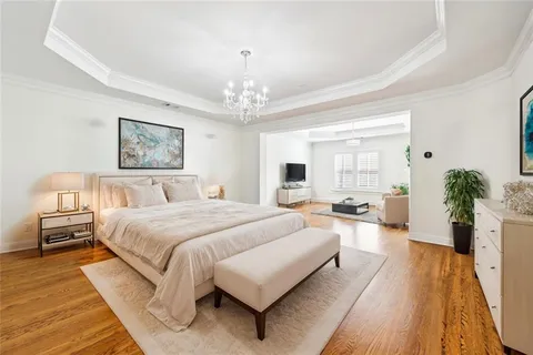 a spacious bedroom with a large bed and a chandelier