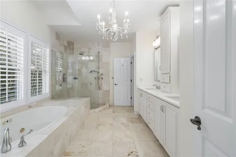 a bathroom with a tub sink shower double vanity