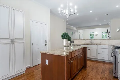 a kitchen with kitchen island granite countertop stainless steel appliances sink cabinets and wooden floor