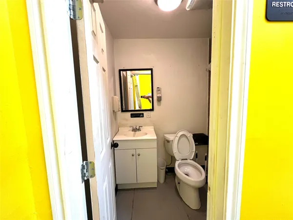 a bathroom with a toilet a sink and a mirror