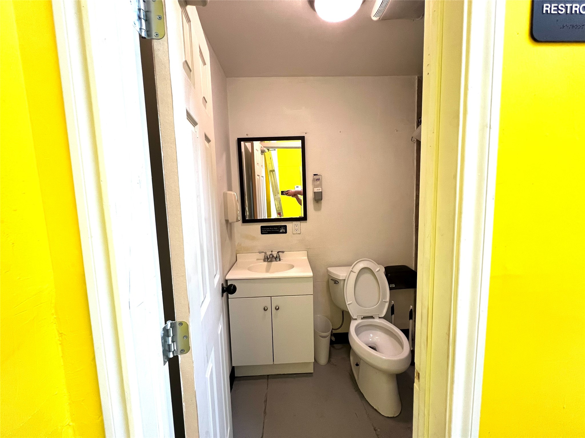 1310 Nance Street, Unit A Houston, TX 77002 - Photo 12 of 18 a bathroom with a toilet a sink and a mirror