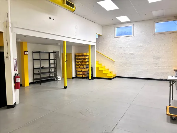 a view of a building with cars parked and a garage