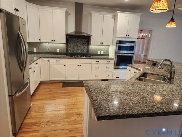 a kitchen with kitchen island granite countertop a sink stove and refrigerator