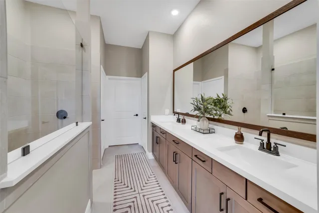 a spacious bathroom with double vanity and a bathtub