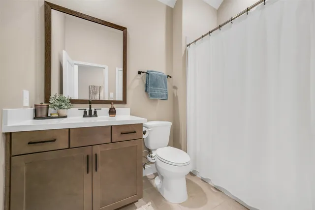 a bathroom with a sink mirror vanity and toilet