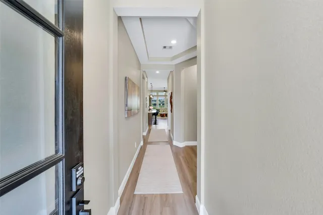 a view of a hallway with wooden floor and staircase