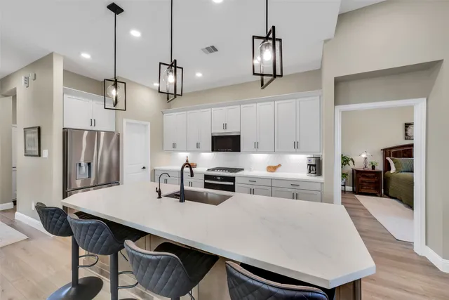 a kitchen with stainless steel appliances a kitchen island a stove a table and chairs