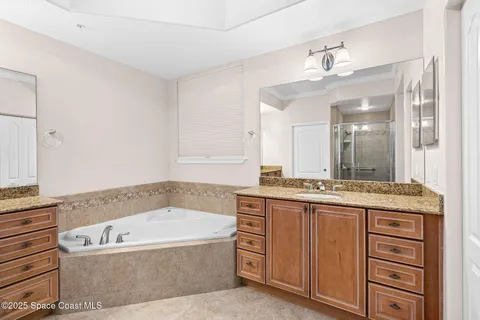 a bathroom with a granite countertop sink mirror and a bathtub