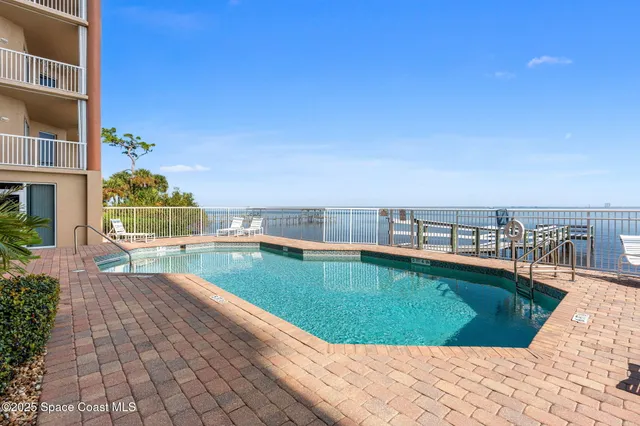 a view of roof deck with two chairs and wooden fence