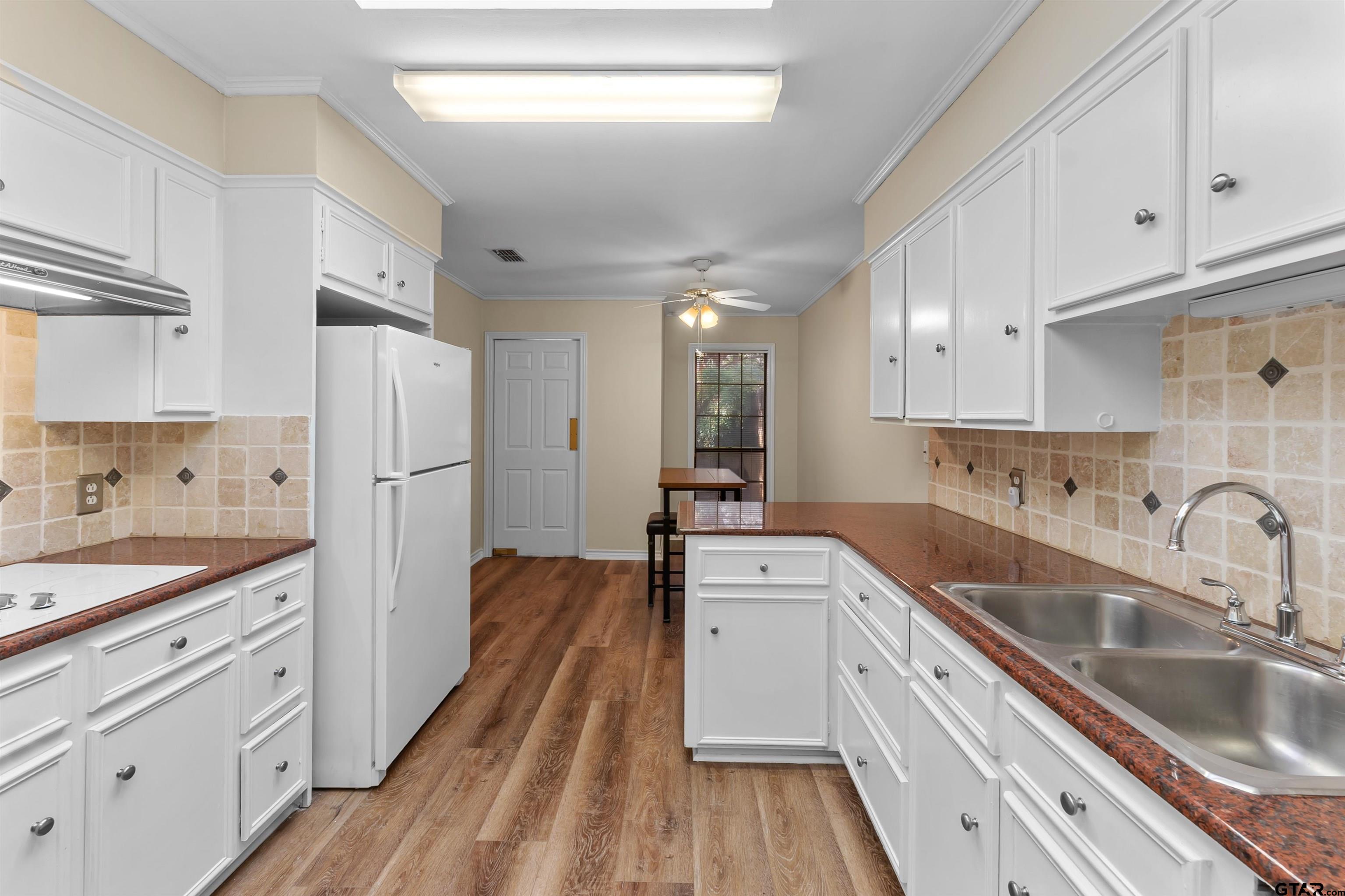 509 Buckingham Place Tyler, TX 75701 - Photo 13 of 35 a kitchen with white cabinets sink and stainless steel appliances