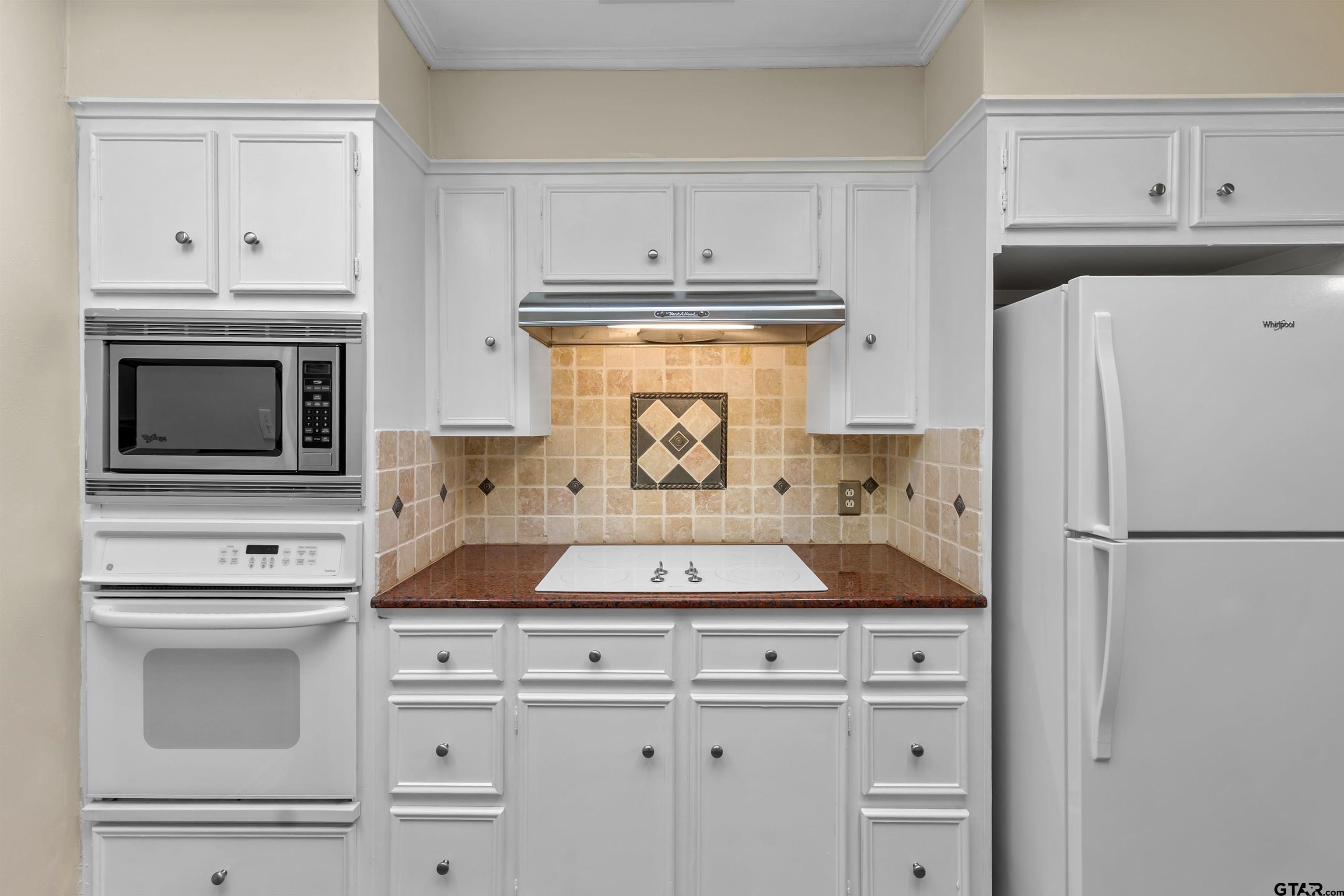 509 Buckingham Place Tyler, TX 75701 - Photo 14 of 35 a kitchen with white cabinets and refrigerator