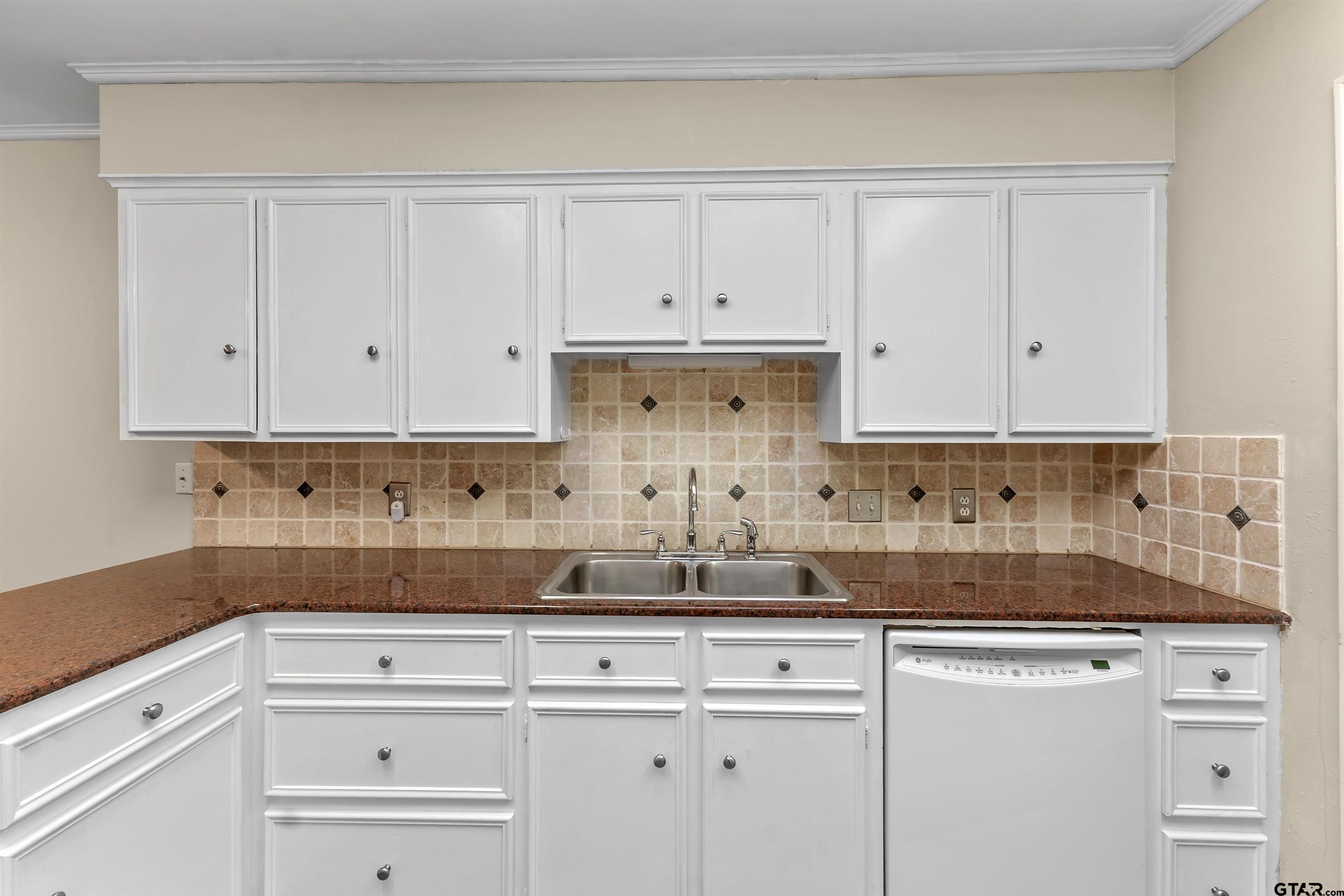 509 Buckingham Place Tyler, TX 75701 - Photo 15 of 35 a kitchen with white cabinets and a sink