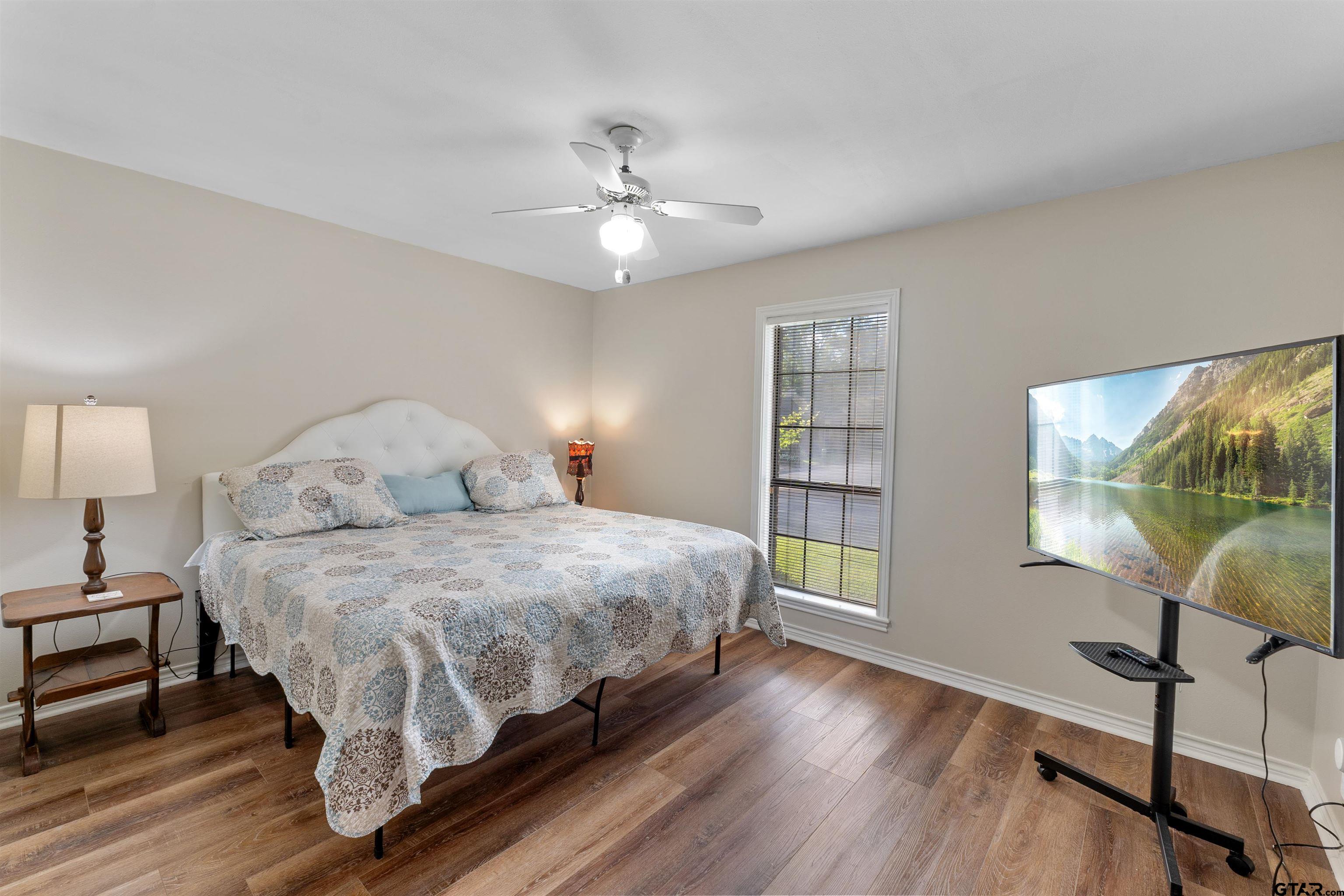 509 Buckingham Place Tyler, TX 75701 - Photo 27 of 35 a bedroom with a large bed and a chandelier