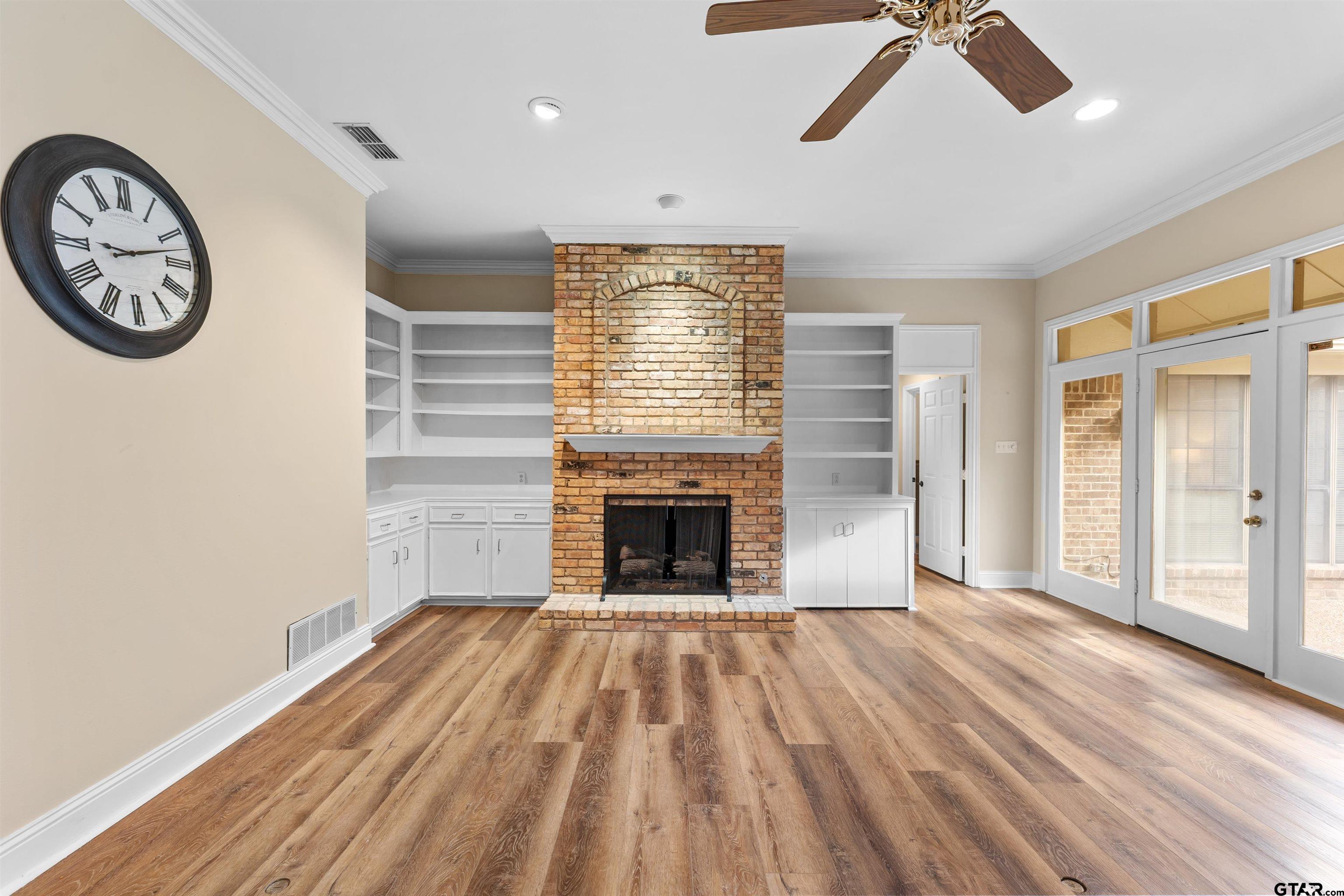 509 Buckingham Place Tyler, TX 75701 - Photo 5 of 35 a view of a livingroom with a fireplace a ceiling fan and wooden floor