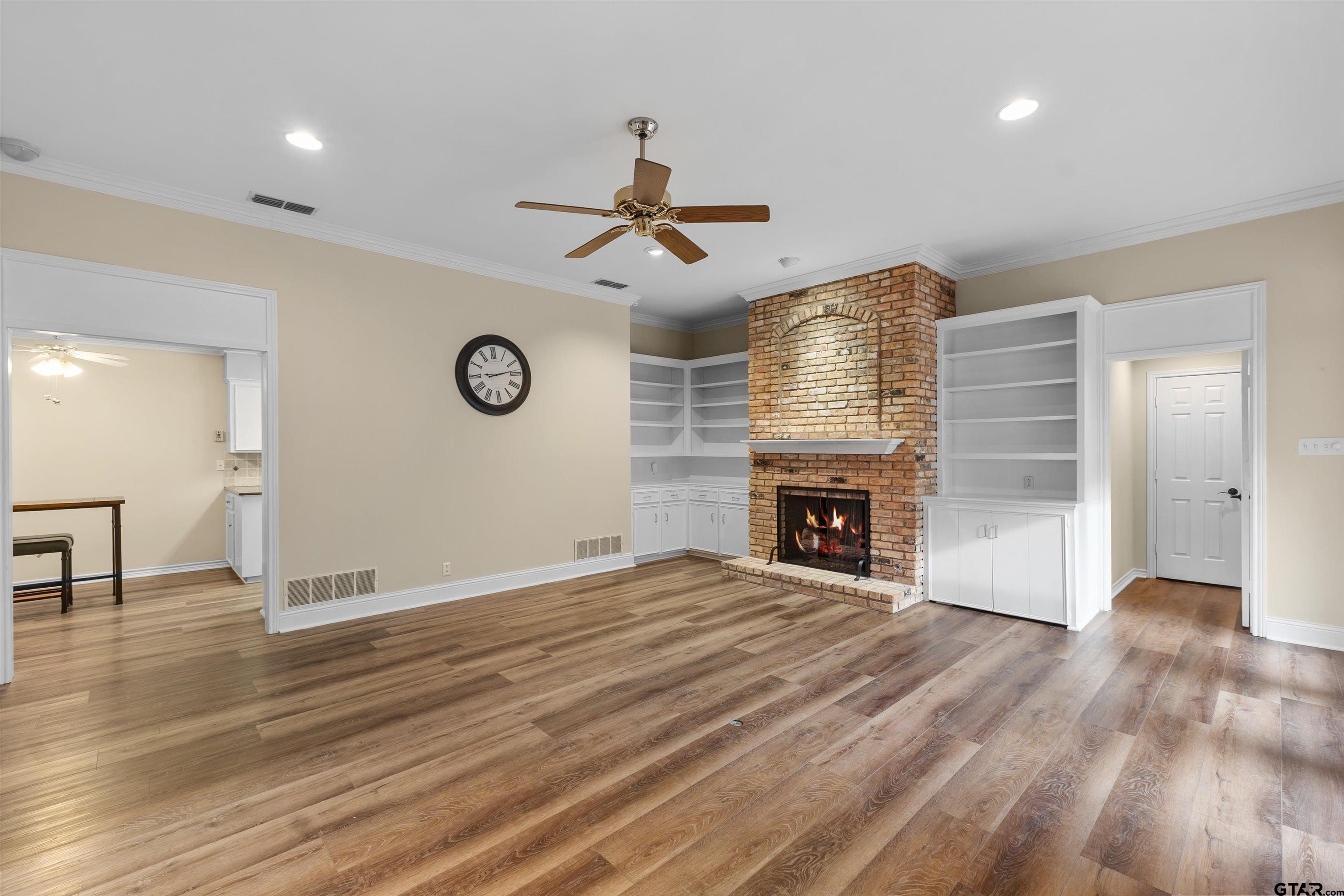 509 Buckingham Place Tyler, TX 75701 - Photo 6 of 35 a view of an empty room with a fireplace and wooden floor