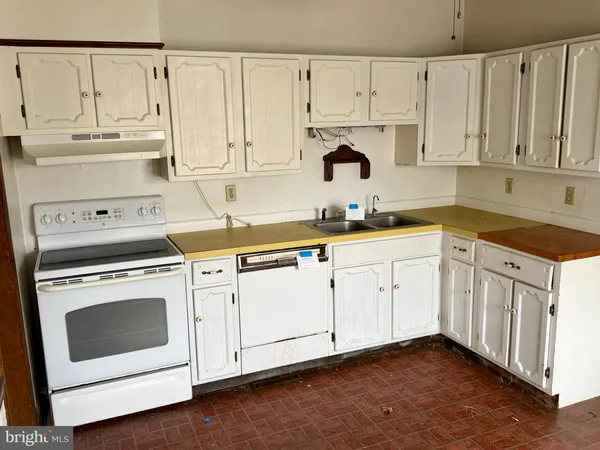 a kitchen with white cabinets and white appliances