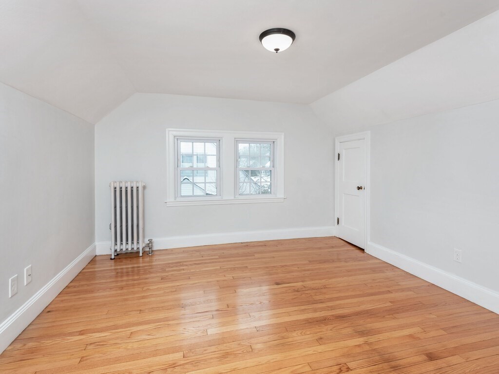 63 Upland Street Worcester, MA 01607 - Photo 22 of 36 an empty room with wooden floor and windows