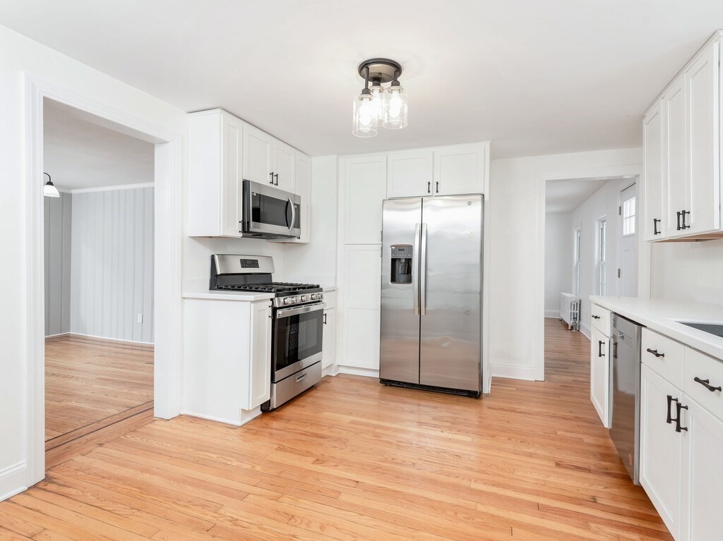 63 Upland Street Worcester, MA 01607 - Photo 4 of 36 a kitchen with stainless steel appliances kitchen island granite countertop a refrigerator and a stove top oven