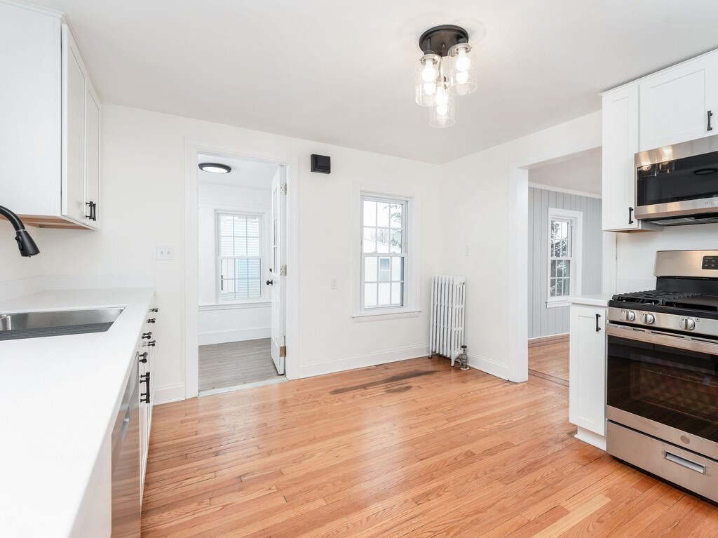 63 Upland Street Worcester, MA 01607 - Photo 5 of 36 a view of a kitchen with a sink stove cabinets and empty room